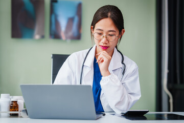 Asian female doctor specializes in psychiatry, providing online consultations and psychotherapy from her desk. She offers diagnosis, treatment, counseling, and medication for mental health disorders.