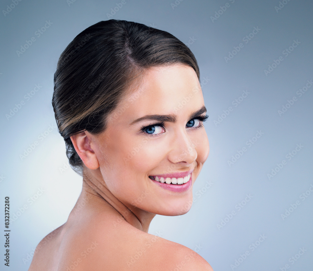 Wall mural Beauty, woman and portrait in studio blue background with smile for skincare, cosmetics and wellness. Female person, happy and confident with glow for healthy face or dermatology isolated on backdrop