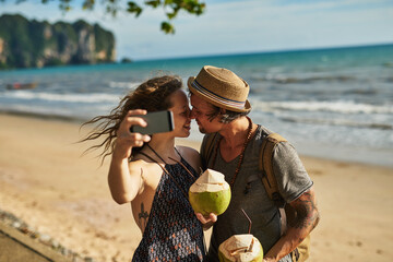Love, couple and selfie for picture on beach for social media update, photography and coconut drink...