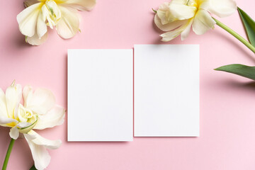 Beautiful wedding invitation card mockup with fresh tulips flowers on pink, white card with copy...
