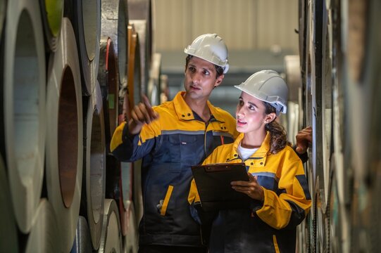 Two professional technician engineer worker use clipboard checking operating equipment machine monitors and check Production process machinery. Two engineer confederate control factory machine