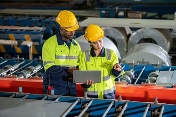 technician Factory mentor teaching apprenticeship trainee operating machine looking monitors and...