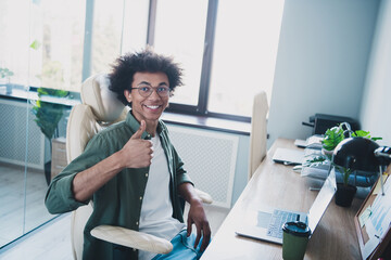 Photo of happy positive broker wear khaki shirt spectacles showing thumb up chatting modern device...