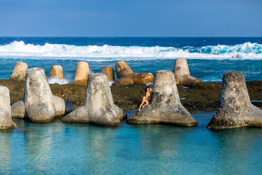 Woman on tetrapods on Yonaguni Island, Yaeyama Islands, Japan
