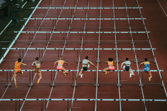 Female track and Field athletes at 100 m hurdles. Dynamic sport photo. Sprint race before world championship and summer game in Paris 2024. Professional Athletics Event.