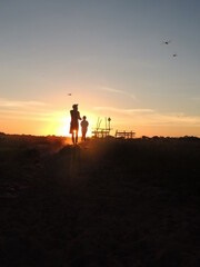 personas caminando bajo un atardecer