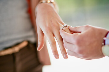 Couple, hand and engagement with ring in home, love and relationship with diamond jewellery on...