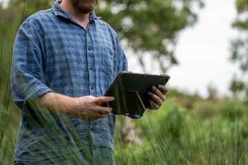 regenerative organic farmer, taking soil samples and looking at plant growth in a farm. practicing sustainable agriculture.