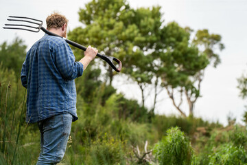 farmer wearing blue shirt and jeans, farmer holding soil, doing soil tests in a home laboratory....