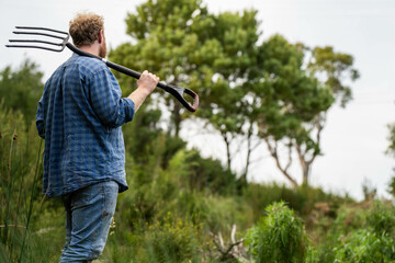 Holding soil in a hand, feeling compost in a field in Tasmania Australia.