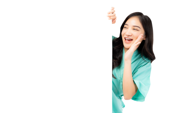 Cheerful young Asian female nurse peeking around a blank whiteboard, smiling and calling out, wearing green medical scrubs. The image captures a friendly healthcare professional in a playful