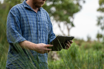 university student conducting research on forest health. farmer collecting soil samples in a test...