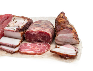 Assorted dry and smoked meat and sausage in baking paper isolated on white