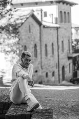 Young model with stylish hairstyle in white active wear on a medieval town setting shooting fashion