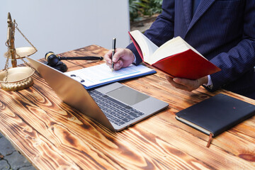 Hands of Asian and African male lawyers working with contract documents and wooden gavel on table...