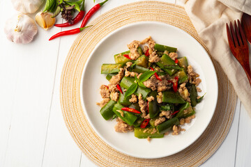 Stir fried Long Eggplant with minced pork and chili basil in white plate.Top view