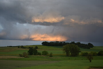 glowing clouds above green farmland