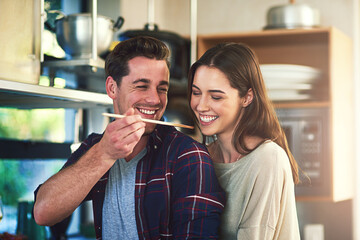 Man, woman and together with spoon for taste test in kitchen, cooking with check on soup for...