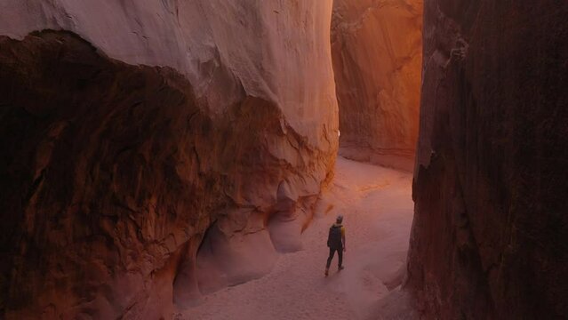 Aerial: Drone Forward Shot Of Man With Backpack Walking Amidst Rock Formations During Vacation In Famous State Park - Moab, Utah