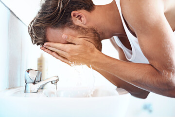 Water, cleaning and man in bathroom for washing face, hygiene or morning routine at sink. Splash,...