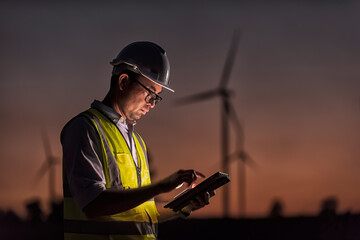  engineers discussing against turbines on wind turbine farm. © ENGINEER - STUDIO