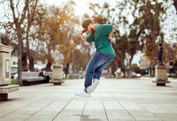 breakdancer performing foot movements or toprock in the air on the street	