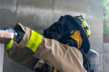A searching firefighter is wearing a black and yellow helmet and a black blindfold to simulate being blind in smoke.