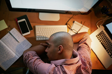 Sleeping, employee and man on table, night and notes for research for web designer and tired in...