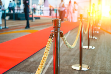 Rope fencing with gold pillars with a red carpet for celebrities and guests of an expensive event...