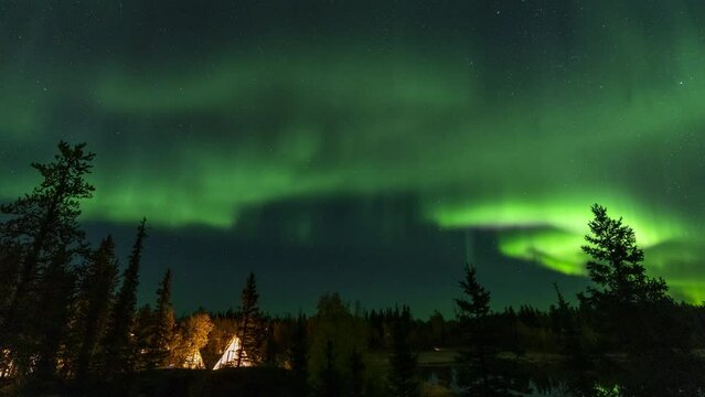 Amazing northern lights dancing over the light up Tipi or Tepees at Aurora Village in Yellowknife, Northwest Territories, Canada.