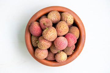 A clay pot filled with delicious ripe lychees. Top view.