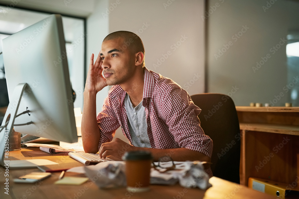 Poster Designer, man and reading with computer in office at night for research, thinking and thoughts for ideas of web design project. Male employee, late and visualization for website development or online