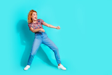 Full size photo of pretty woman arms pull empty space wear t-shirt isolated on teal color background