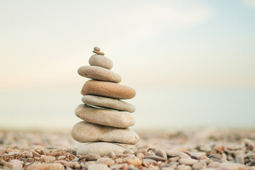 A stack of rocks on a beach. The rocks are of different sizes and are piled on top of each other. Concept of tranquility and peace, as the rocks seem to be in harmony with their surroundings
