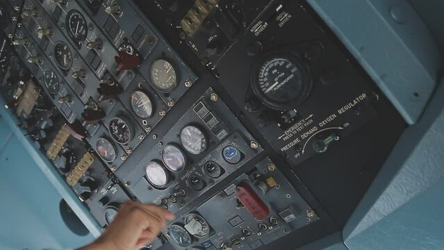 The pilot presses the power buttons on the control panel to control the aircraft in front of cockpit windshield