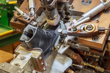 Workshop of shoes factory with equipment for stretching and attaching.