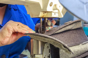 A shoe factory worker sews on a special machine.