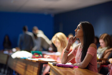 Woman, university and student with thinking in lecture hall for lesson, teaching and learning on...