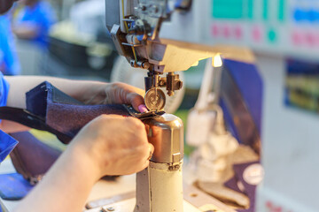 The staff of footwear factory works on special sewing machines.