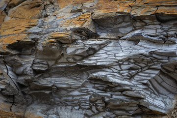 Old Aged Shabby Cliff Face And Divided By Huge Cracks And Layers