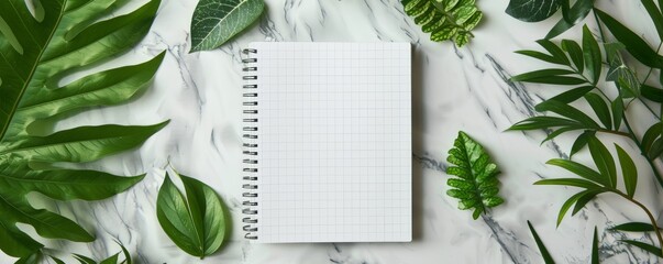 Top view of a white spiral notebook with pen on marble, flat lay mockup