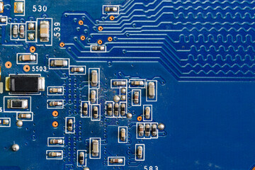 A fragment of a blue computer board with capacitors