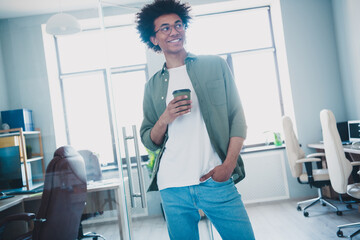 Photo of happy positive broker wear khaki shirt spectacles drinking hot beverage indoors workshop...