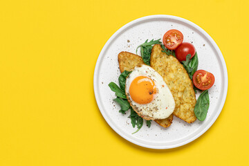 Egg, hashbrown and salad in plate on yellow background with copy space