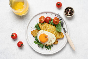 Egg, hashbrown and salad in plate on white background with copy space