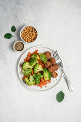 Healthy food broccoli, carrots and vegetable meatballs on a plate top view on a white background with copy space