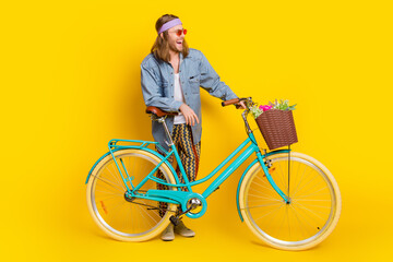 Full size photo of cool young man bike wear denim shirt isolated on yellow color background