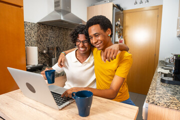 Male gay couple embracing during video call from home