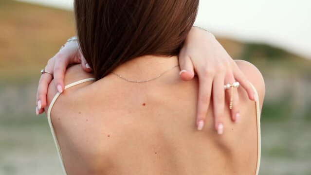 The girl in a backless dress. The girl with loose black hair strokes her back.