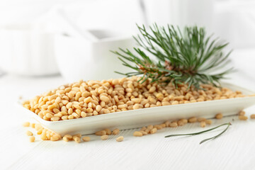 Peeled pine nuts on a white wooden table.